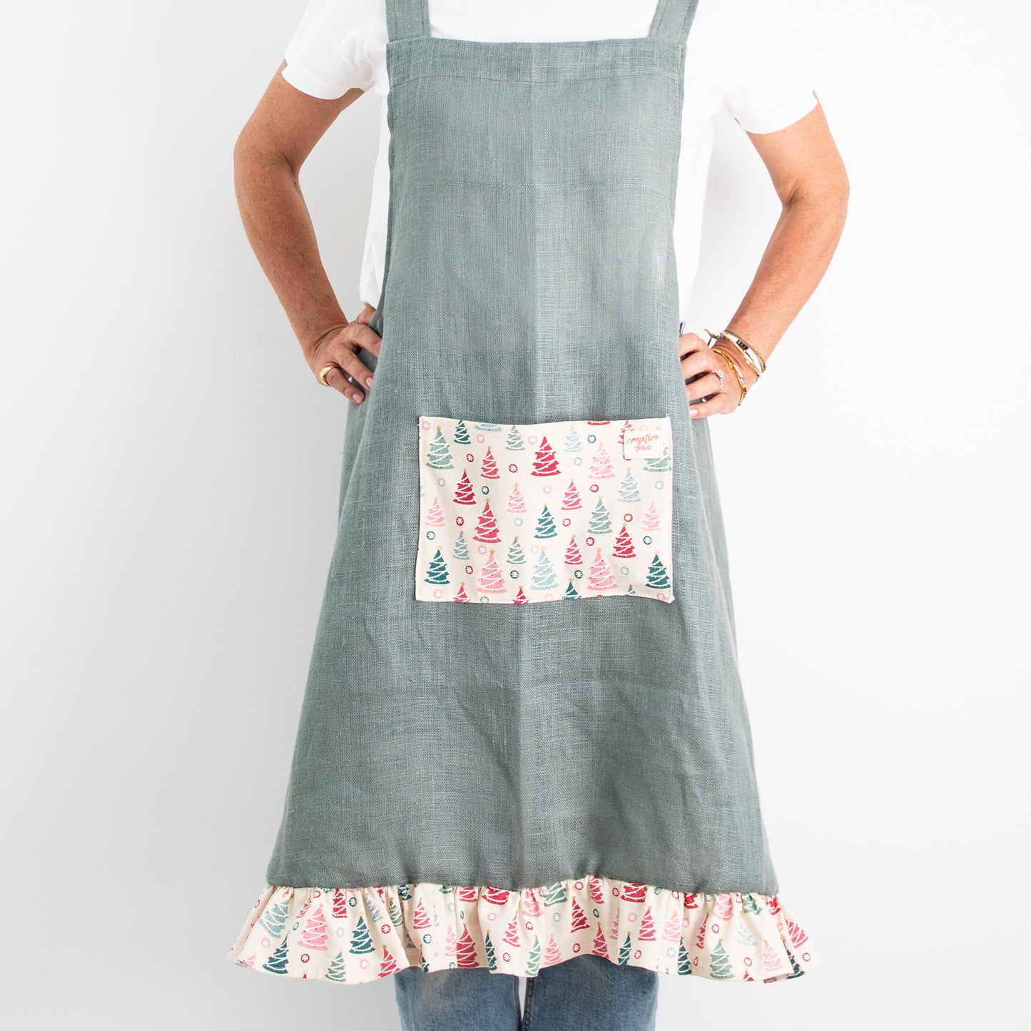 green linen apron with christmas fabric on pocket and frill