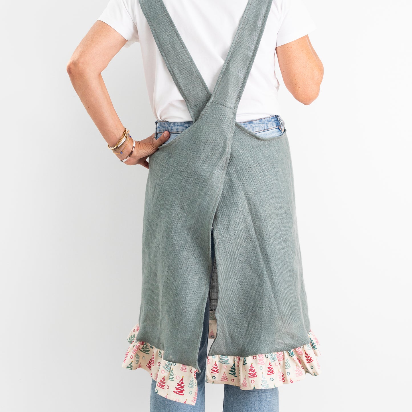rear view of green linen apron with christmas fabric on pocket and frill