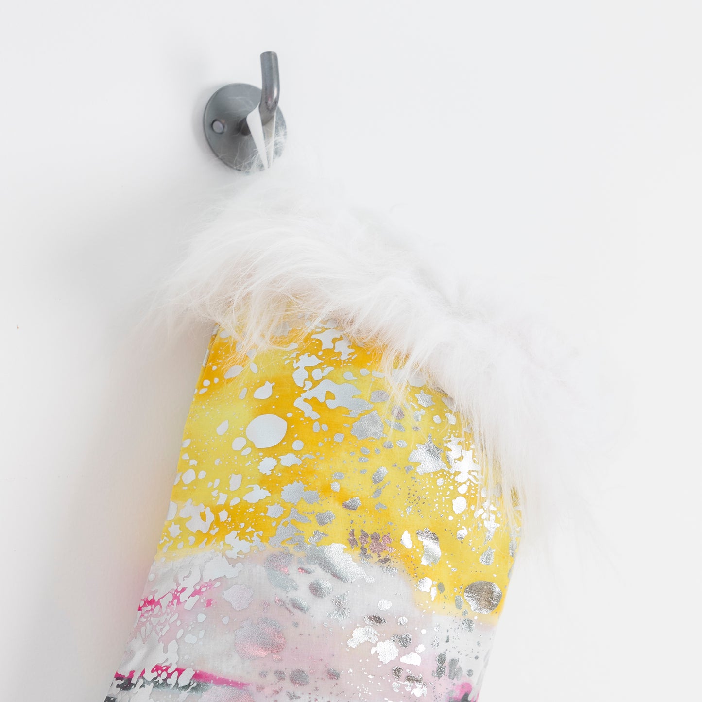 close up of yellow, pink & silver xmas stocking with faux fur trim