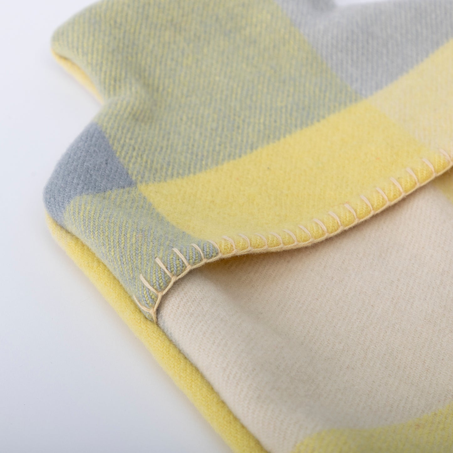 Up close image of the blanket stitching on the lemon & grey hot water bottle cover