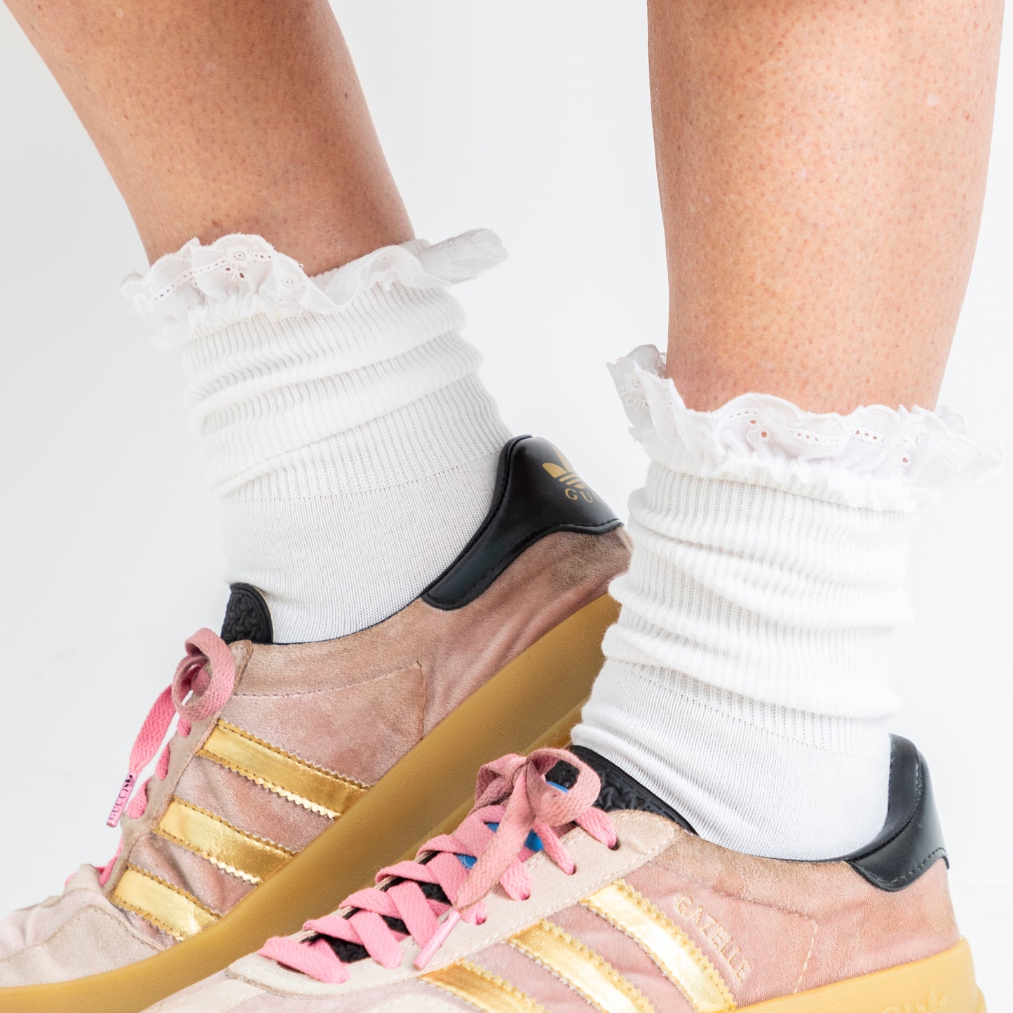 lace trim white ankle socks worn here, bunched up with sneakers - close up shot