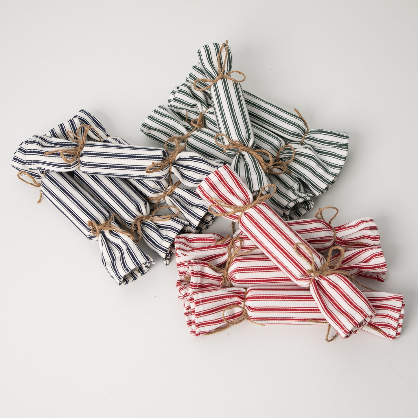 blue, green and red ticking fabric bon bons in a pile on a white background
