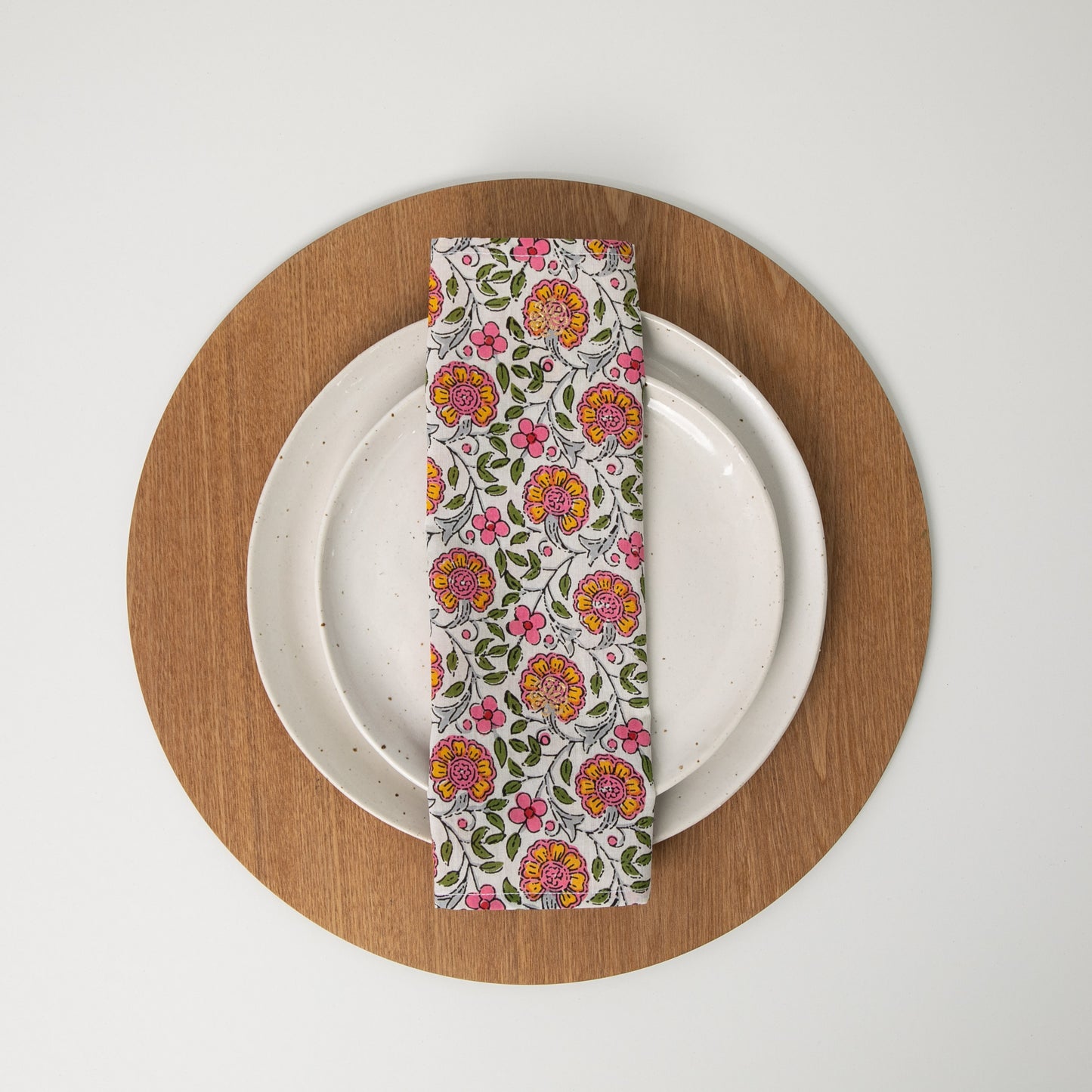 floral cotton napkin folded in thirds, sitting on white plates