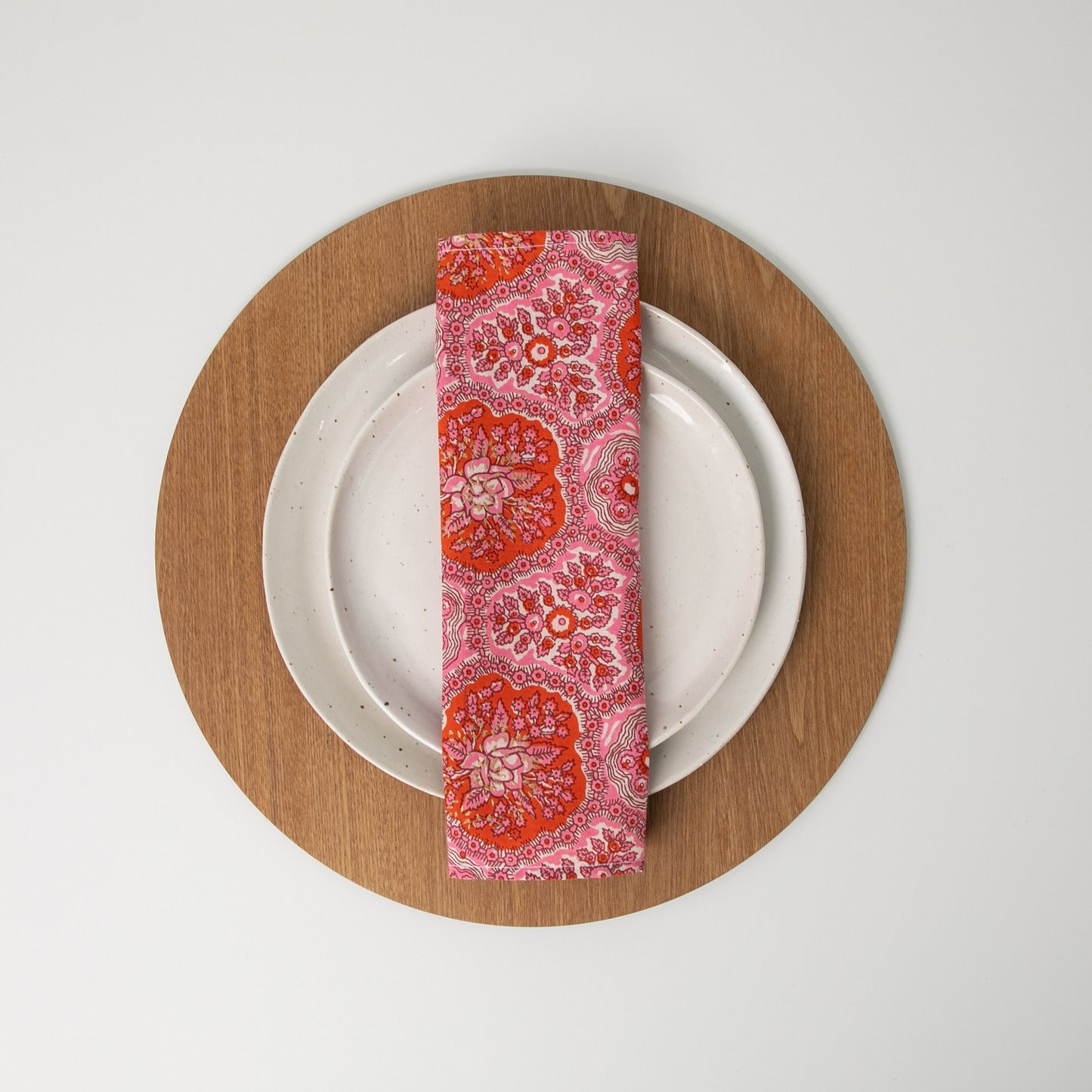pink napkin folded in thirds sitting on white plates