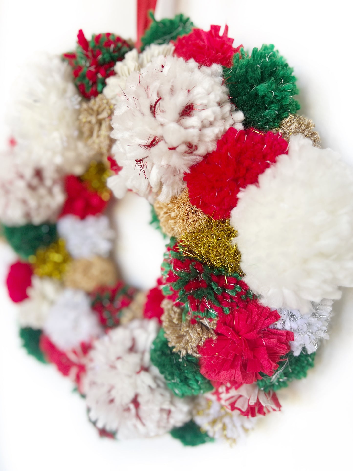
                  
                    Red, Green, White Pom Pom Christmas Wreath. Handmade using a variety of yarns.
                  
                