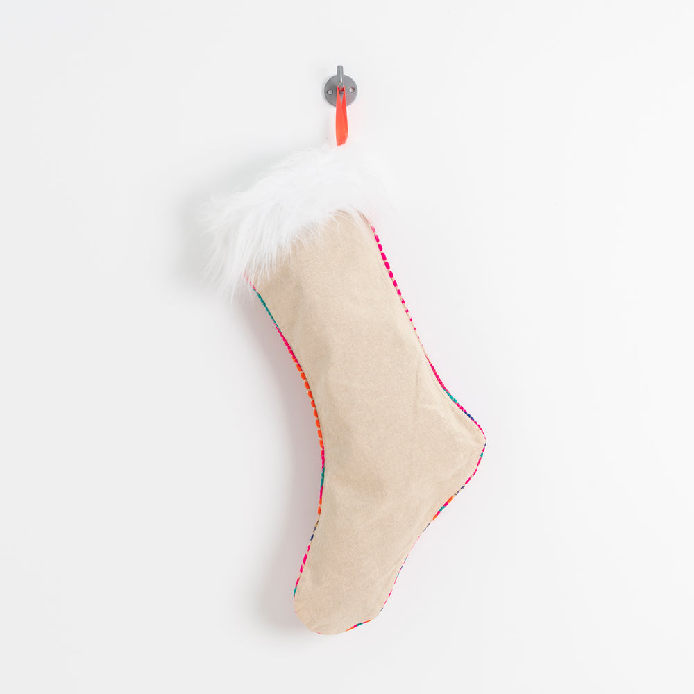 reverse side - natural linen. beautiful woven pink fabric stocking with faux fur trim hanging by a bright orange ribbon.