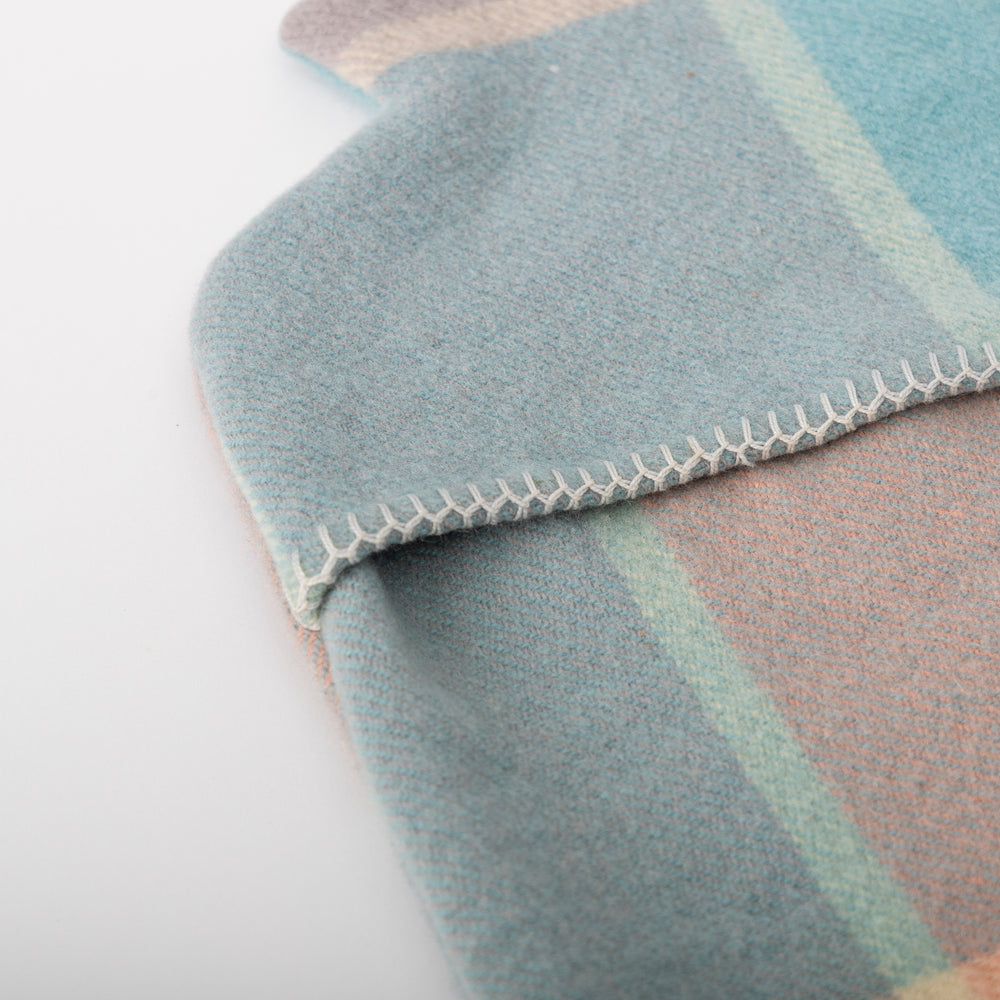 
                  
                    Up close image of the blanket stitching on the pastel blue & pink hot water bottle cover
                  
                