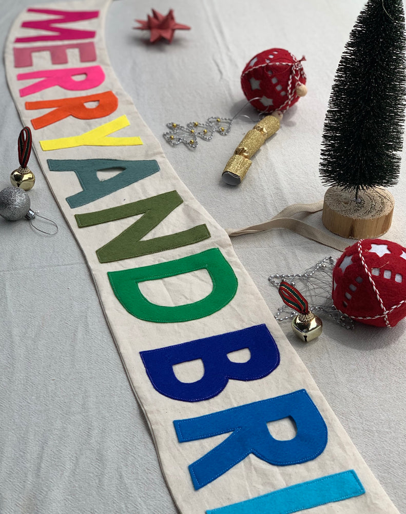 
                  
                    Merry and Bright Banner lying on table
                  
                